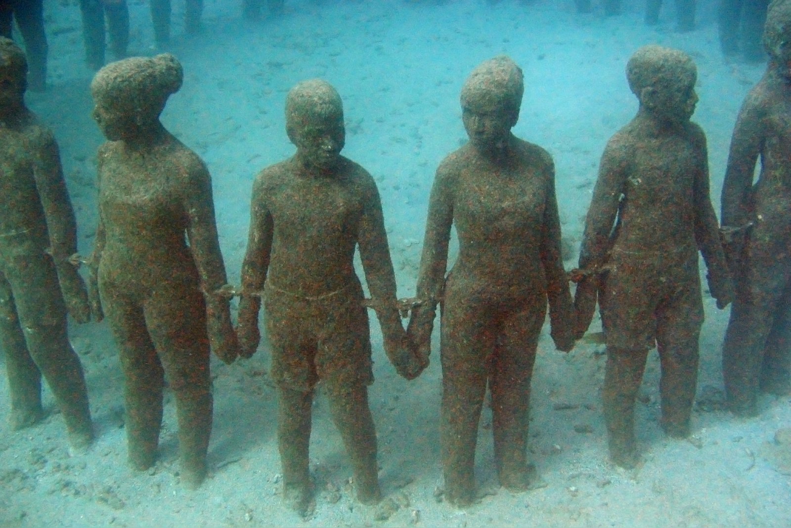 Close view of Vicissitudes, children holding hands beneath the sea in Molinière Bay, Grenada