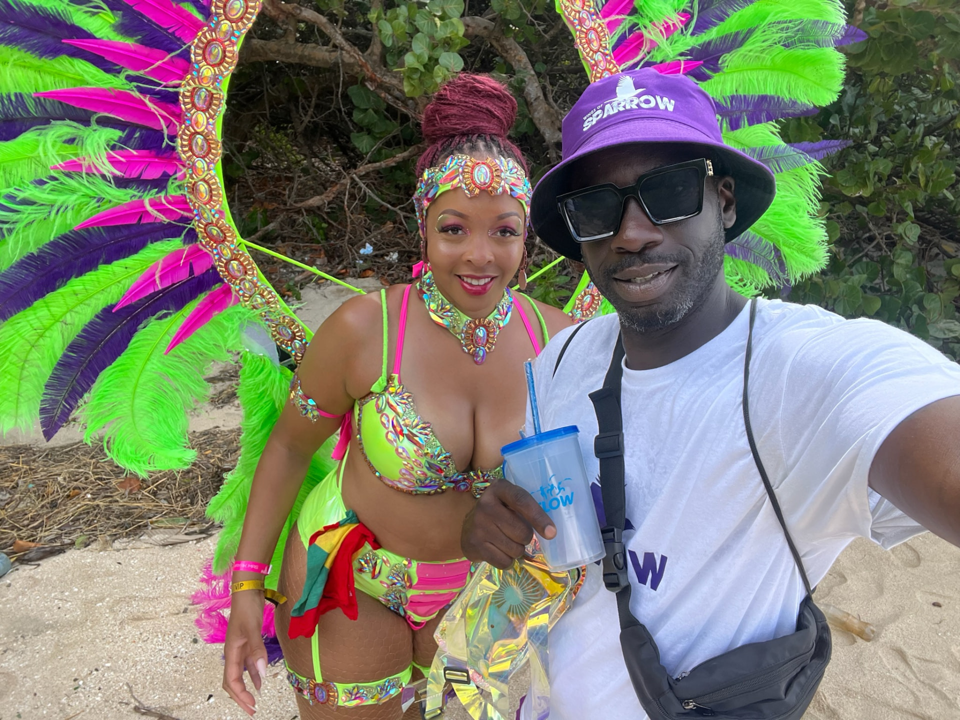 Shawn and Daimon in neon green and pink Carnival costumes on the beach