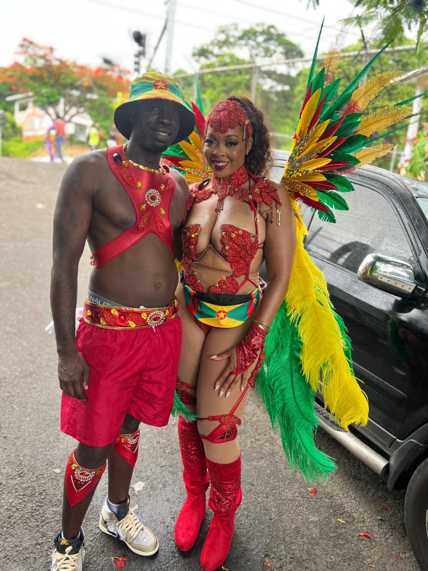 Shawn and Daimon in red, gold and green Grenada-inspired Carnival costumes