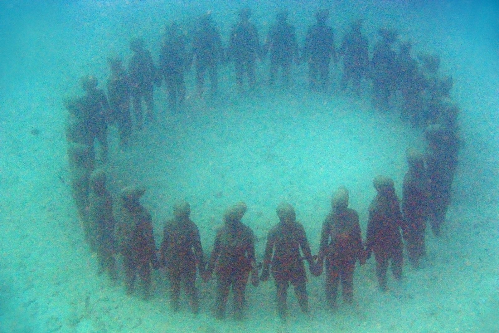 Vicissitudes, the full ring of children joined hand in hand on the sea floor of Molinière Bay, Grenada