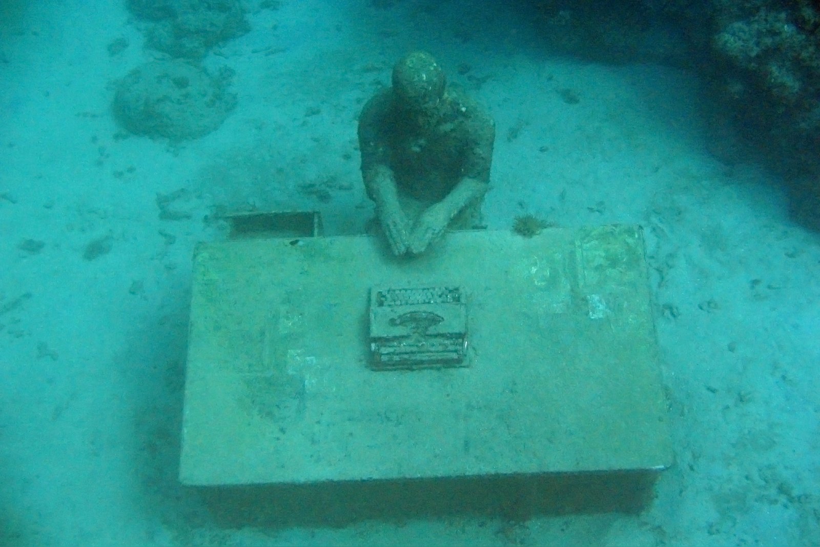 The Lost Correspondent, a figure at a desk of typeset, Underwater Sculpture Park, Grenada